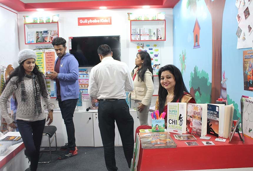 Families reading GullyBaba Kids books at the fair pavilion